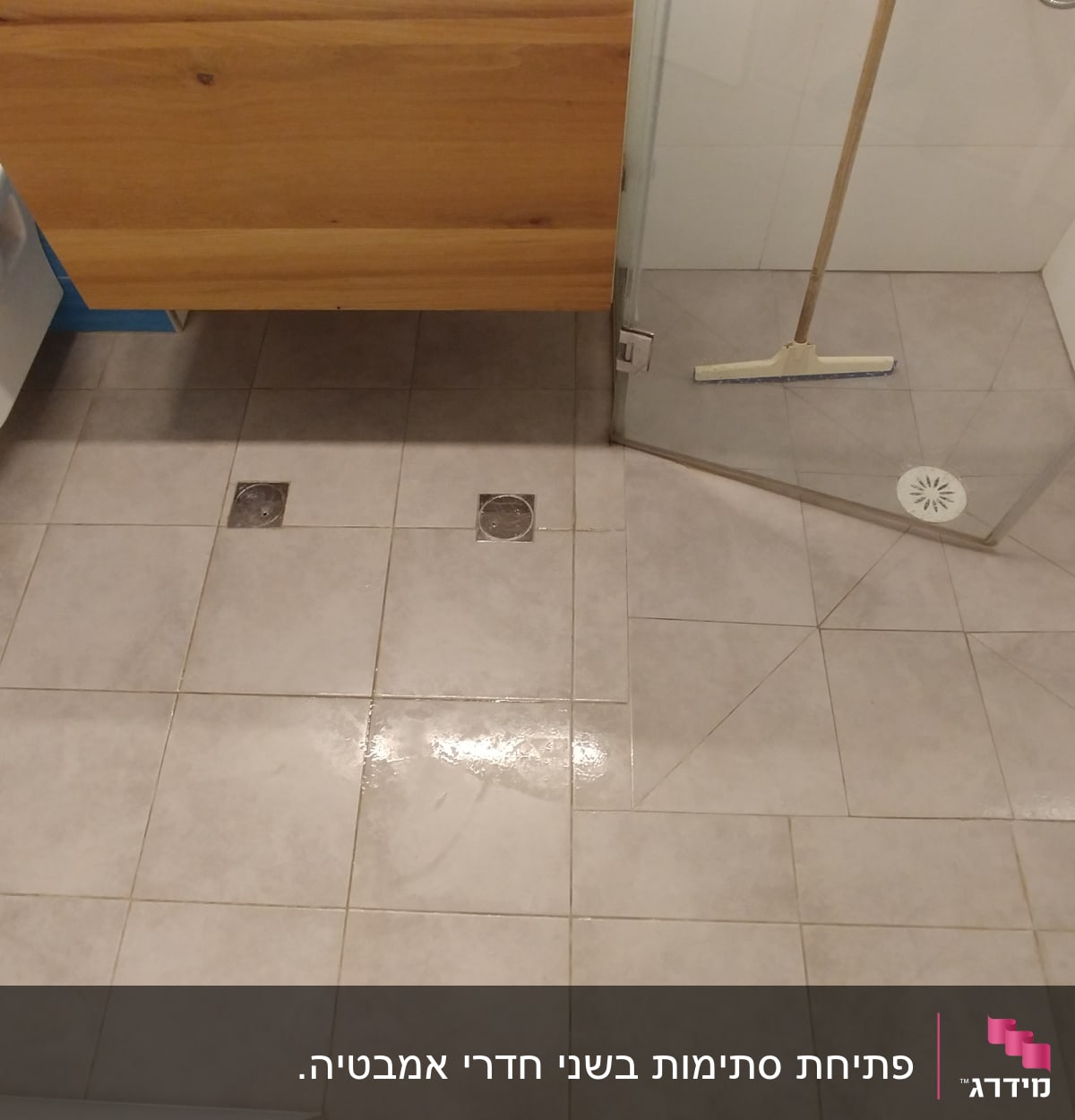 רצפת חדר אמבטיה עם פתחי ניקוז ומגב